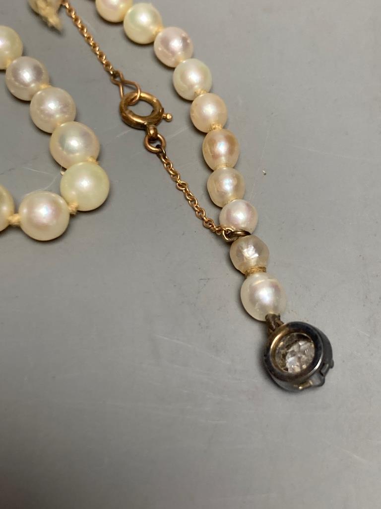 An early 20th century single strand graduated cultured? pearl necklace, with old cut diamond set white metal clasp, 42cm, gross weight 13.8 grams (string broken)